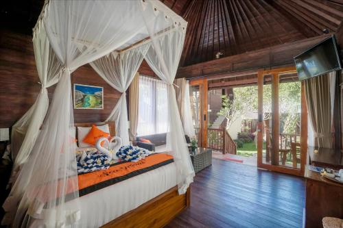 a bedroom with a canopy bed in a house at Sea Terras Suite and Luxury in Nusa Penida