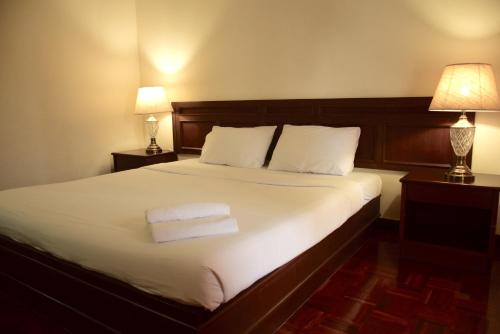 a bedroom with a bed with two towels on it at Puangpen Villa Hotel in Hua Hin