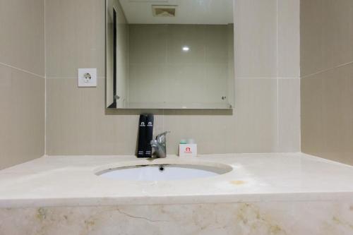 Ένα μπάνιο στο Simply Furnished 1BR at Paramount Skyline Apartment By Travelio