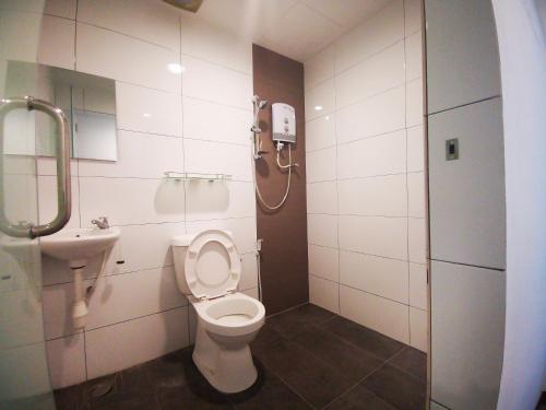 uma casa de banho com WC e um telefone na parede em Amanjaya Hotel em Sungai Petani