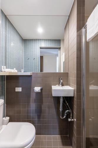 a bathroom with a sink and a toilet and a mirror at Best Western Melbourne City in Melbourne