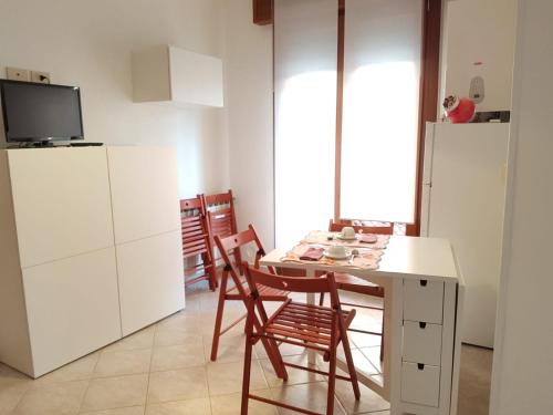 a kitchen with a table and chairs and a refrigerator at A 3 PASSI DAL MARE in Chioggia