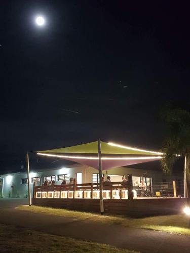 a building with a roof with lights on it at night at Auberge de Poé in Bourail