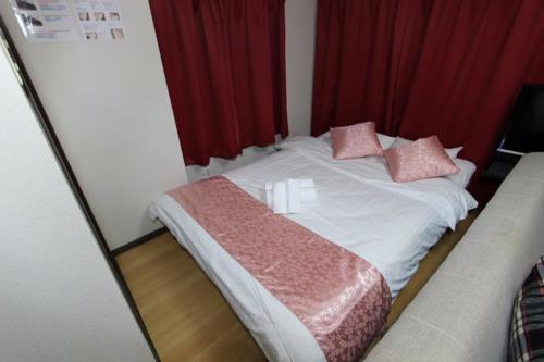 a bed with pink pillows on it in a room at La Foret Fujimi in Hiroshima