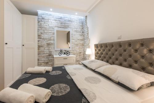 a bedroom with a large bed and a brick wall at Pipo in Rijeka