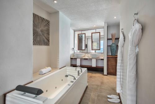 a white bathroom with two sinks and a tub at Solana Beach Mauritius - Adults Only in Belle Mare