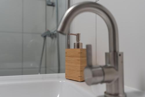 ein Waschbecken mit einem Holzblock neben einem Wasserhahn in der Unterkunft CasaMare in Egmond aan Zee