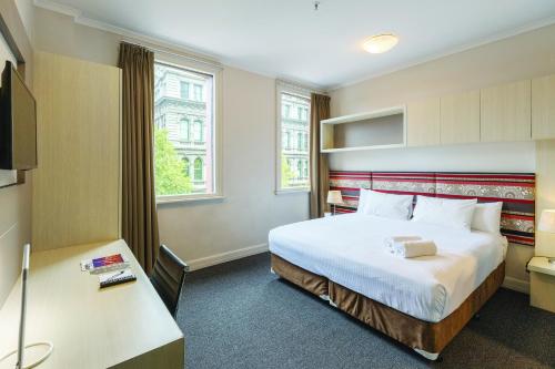 a hotel room with a bed and a tv at Best Western Melbourne City in Melbourne