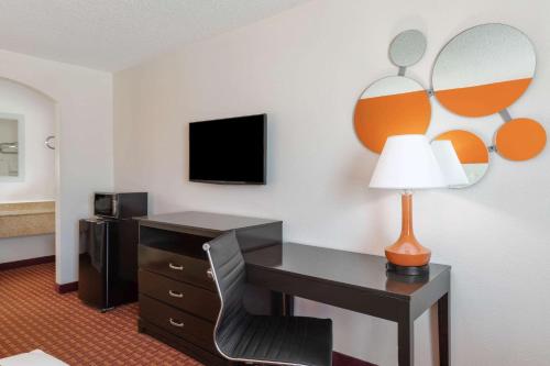 a hotel room with a desk and a lamp at Howard Johnson by Wyndham Rock Hill in Rock Hill