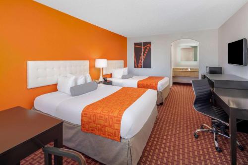 a hotel room with two beds and a desk at Howard Johnson by Wyndham Rock Hill in Rock Hill