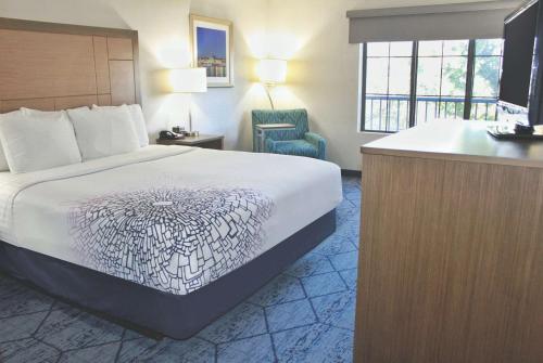 a hotel room with a bed and a television at La Quinta by Wyndham NE Long Beach/Cypress in Hawaiian Gardens