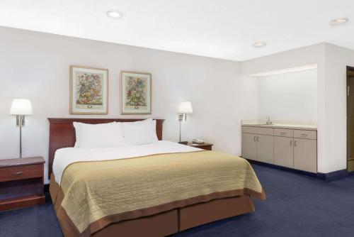 una camera con un grande letto e un lavandino di Baymont by Wyndham Zanesville a Zanesville