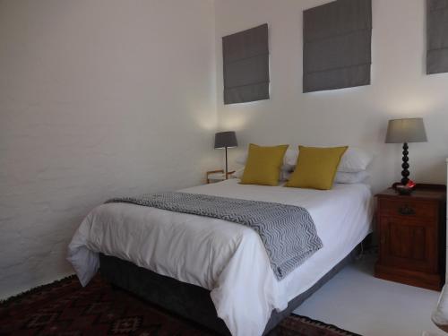 a bedroom with a white bed with yellow pillows at 273 Rhino retreat-solar backup in Centurion