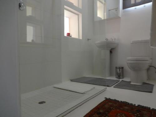 a white bathroom with a toilet and a sink at 273 Rhino retreat-solar backup in Centurion