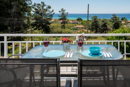 a table on the balcony with a view of the ocean at Georgalas Rest Apartments in Nea Kalikratia