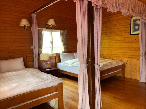 a bedroom with two beds in a log cabin at Cingjing Brilliant Twins of Seattle in Renai