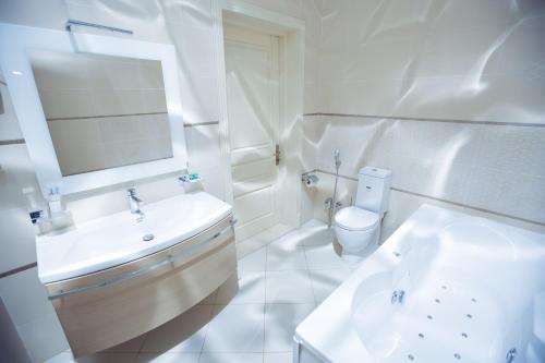 a white bathroom with a sink and a toilet at Goy Gol Lake Resort in Goygol
