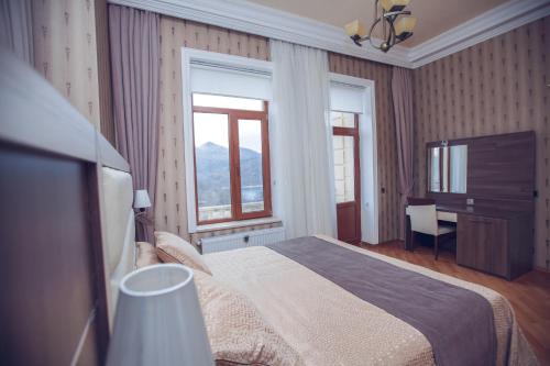 a bedroom with a bed and a desk and window at Goy Gol Lake Resort in Goygol