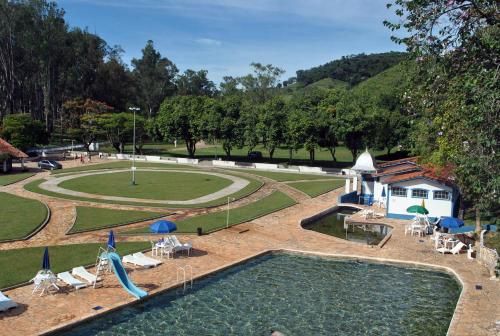 a view of a swimming pool and a park at Hotel Termópolis in São Sebastião do Paraíso