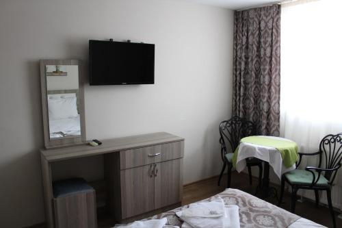 Habitación de hotel con cama y TV en la pared en Ararat Hotel, en Estambul