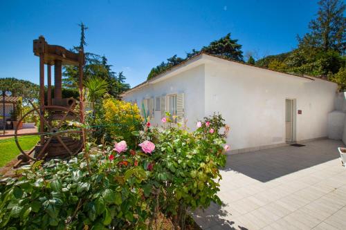 a white building with flowers in front of it at Hotel O Sole Mio in SantʼAgata sui Due Golfi