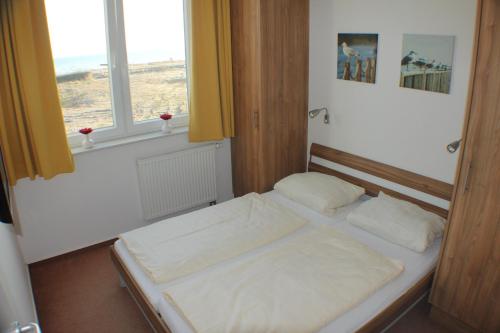 a small bed in a room with a window at Ferienwohnung Windrose 7 in Großenbrode