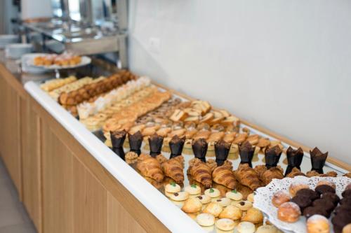 a buffet line with various pastries and other pastries at Hotel O Sole Mio in SantʼAgata sui Due Golfi