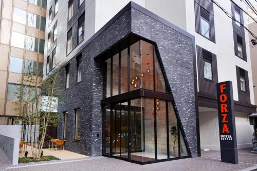 a black brick building with a sign in front of it at HOTEL FORZA HAKATA-GUCHI in Fukuoka