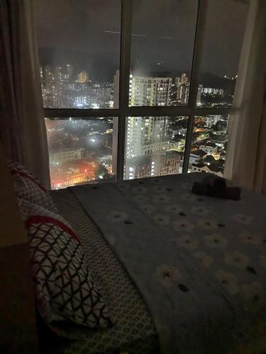 a bedroom with a bed and a window with a view at Strait Garden Suites X Ace Pro @ George Town in Jelutong