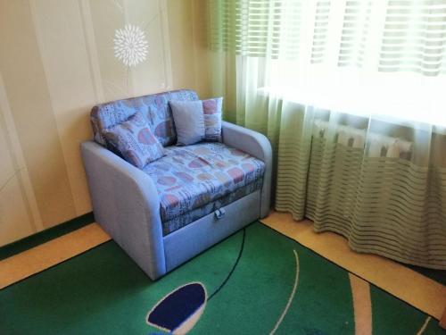a chair sitting in a room with a window at Apartments on Dontsya, 12 in Kyiv