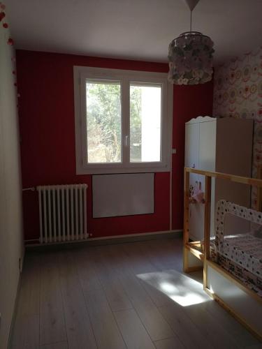 une pièce vide avec une fenêtre et des murs rouges dans l'établissement F3 lumineux confortable, à Sète