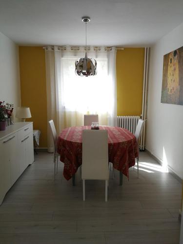 une salle à manger avec une table et des chaises rouges dans l'établissement F3 lumineux confortable, à Sète