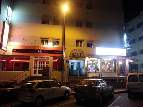 two cars parked in front of a building at night at Hostal Casa de Huéspedes San Fernando - Adults Only in Playa del Ingles