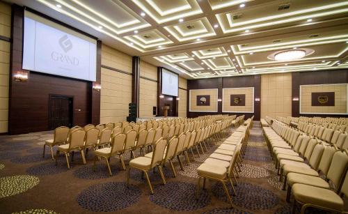 a conference room with chairs and a screen in it at Grand Hotel & Convention Center Karaman in Karaman