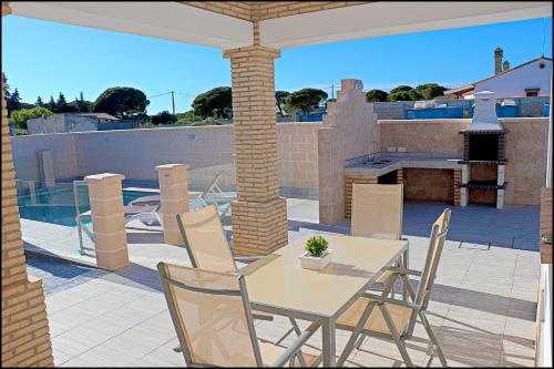 un patio con tavolo e sedie su un patio di Chalet Peñuelas con piscina a Conil de la Frontera