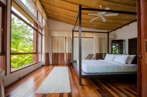 a bedroom with a bed and a large window at Amatapura Beach Villa 6 in Ao Nam Mao