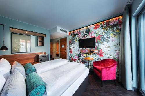 a hotel room with a bed and a tv at Maison Schiller by DesignCity Hotels in Munich