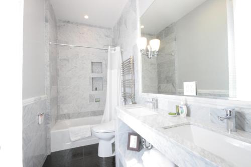 a white bathroom with a sink and a toilet at Monte Cristo Bed and Breakfast in San Francisco