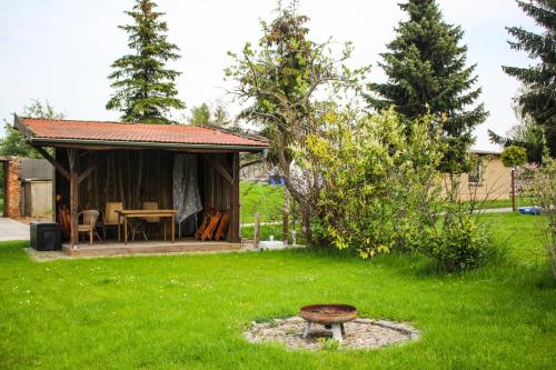 a small cabin with a table and a chair in a yard at Bauernhof Gerth in Göllnitz