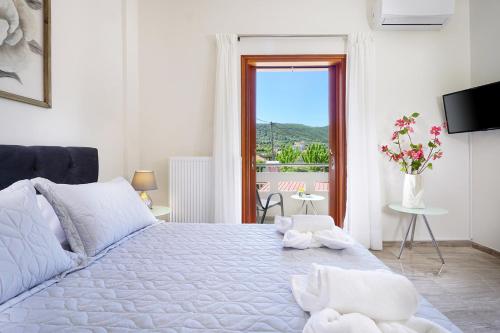1 dormitorio con 1 cama blanca grande y ventana en Anthos Village, en Ayiá