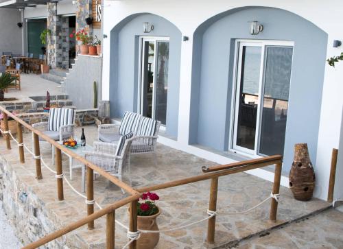 a patio with two chairs and a table on a building at Iliana Sea Side House in Elounda
