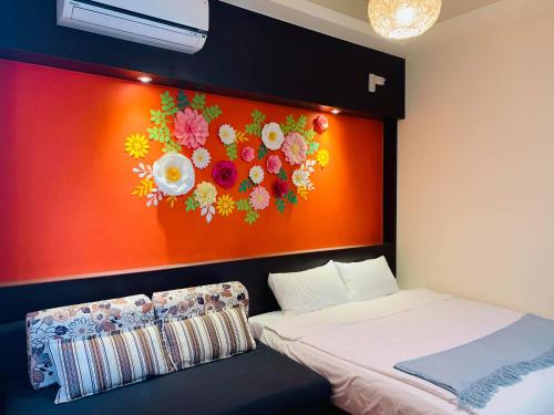 a bedroom with a painting of flowers on the wall at 198紅帽民宿l市區l電梯l停車場 in Magong