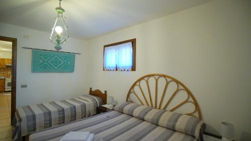 a bedroom with two beds and a window at Residenza Su Prelau in Gonnesa