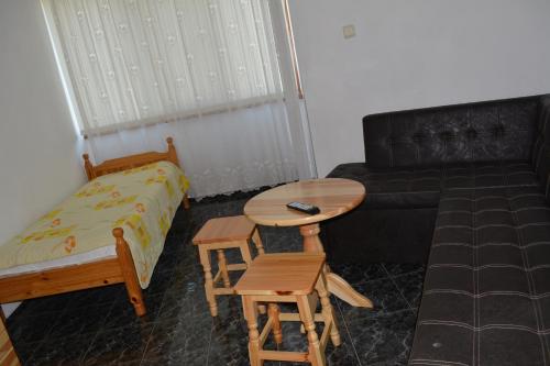 a living room with a couch and a table and a bed at Guest House Orbita in Tyulenovo