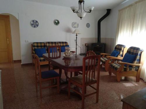 ein Esszimmer mit einem Tisch, Stühlen und einem Kamin in der Unterkunft Casa Vall de Almonacid in Vall de Almonacid