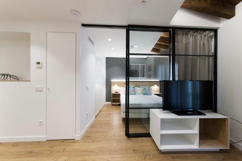a bedroom with a bed and a large glass wall at Antique Pamplona Tres Reyes Apartments in Pamplona
