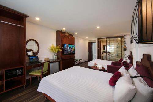 1 dormitorio con 1 cama blanca grande y escritorio en Vision Premium Hotel en Hanoi