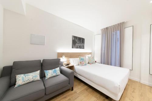 パンプローナにあるAntique Pamplona Tres Reyes Apartmentsのリビングルーム(ベッド1台、ソファ付)