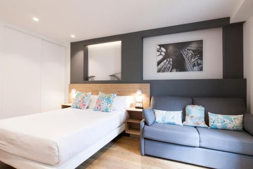 a bedroom with a bed and a couch at Antique Pamplona Tres Reyes Apartments in Pamplona