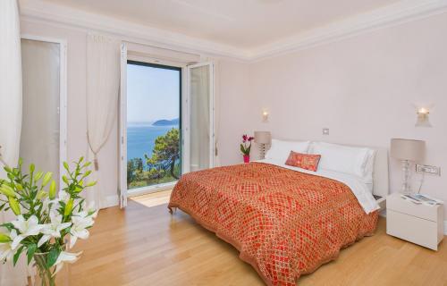 una camera bianca con un letto e una grande finestra di Villa Touran a Orasac (Valdinoce)